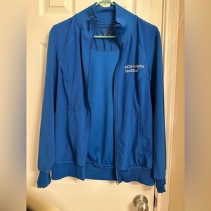 Royal blue infinity scrub jacket with HCA embroidery. No stains. Size small